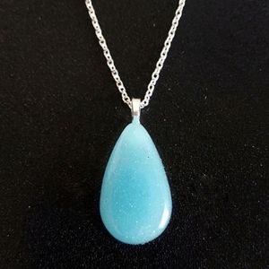 Ice blue shimmery glow in the dark teardrop pendant on 20 inch silver necklace